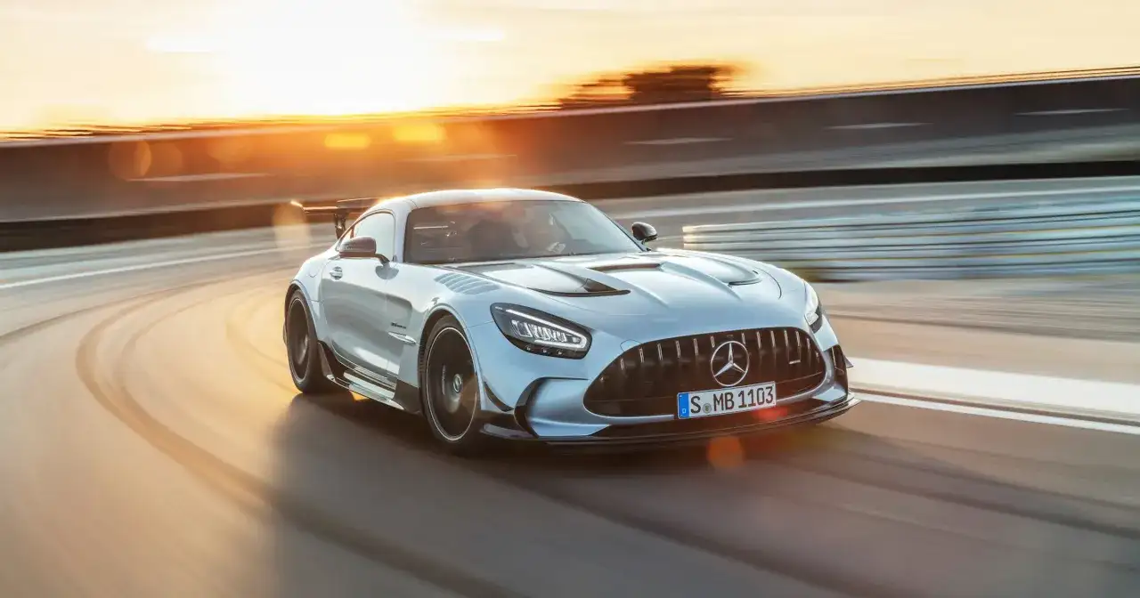 Srebrny Mercedes-AMG GT Black Series na torze wyścigowym, w promieniach zachodzącego słońca.