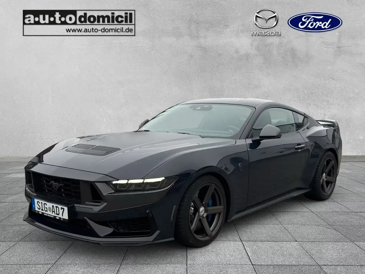 Ciemnogranatowy Ford Mustang z 2023 roku, z czarnymi felgami i sportowym wyglądem. Sprawdź atrakcyjną mustang cena!