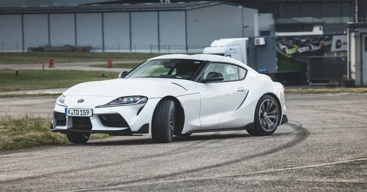 Biała Toyota GR Supra na torze, zostawiająca ślady opon.
