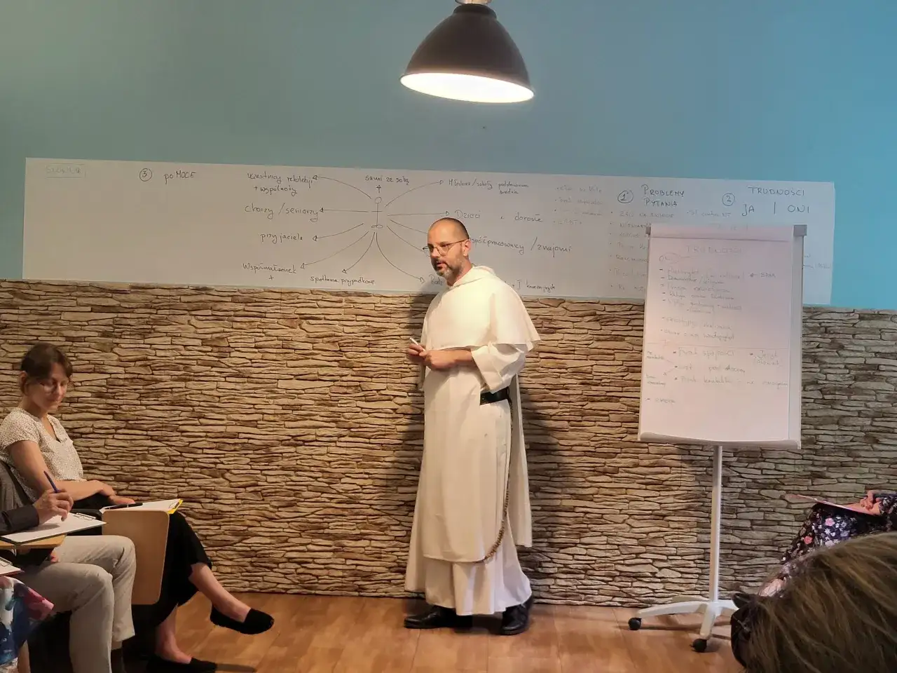 Wykład o tym, jak rozmawiać z niewierzącymi rodzicami o chęci powrotu do kościoła. Na tablicy schemat relacji i trudności.