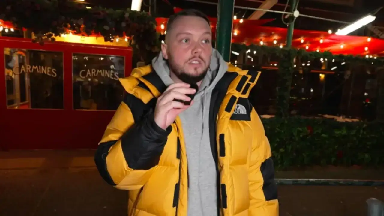 Książulo w żółtej kurtce przed restauracją Carmines, gdzie jego recenzja obiadu była negatywna.
