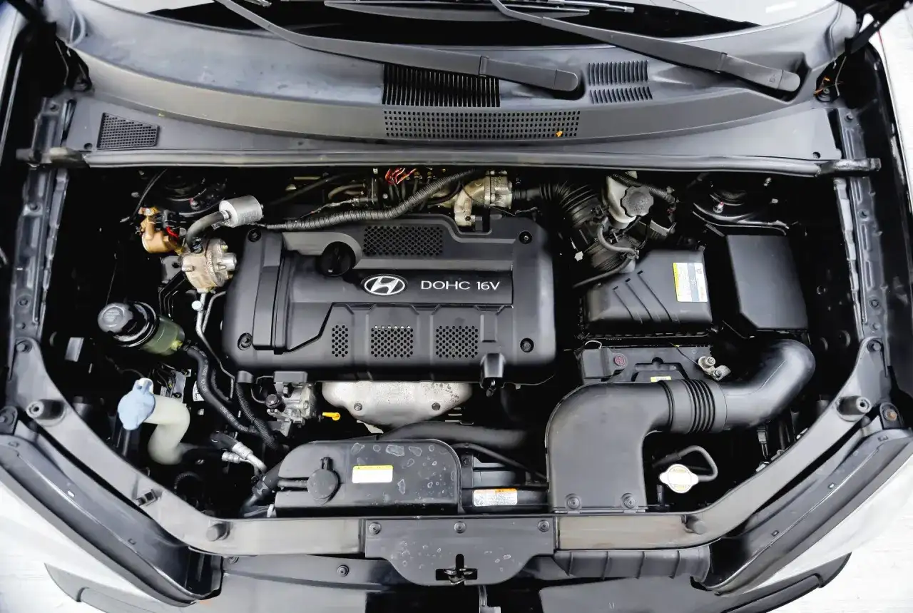 Silnik DOHC 16V w Hyundai Tucson 2007. Widoczny układ dolotowy i elementy osprzętu.