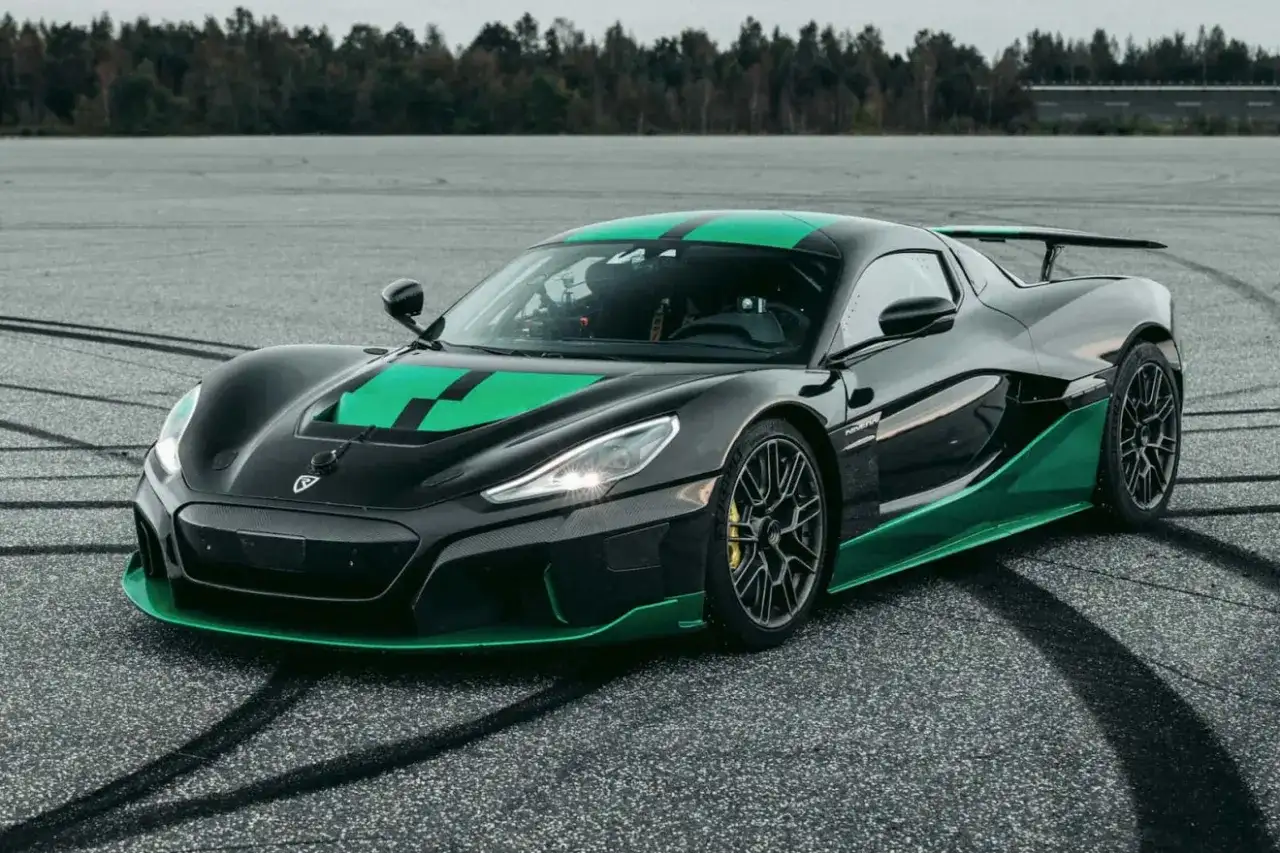 Czarny Rimac Nevera z zielonymi akcentami na masce i progach, gotowy do jazdy po torze.