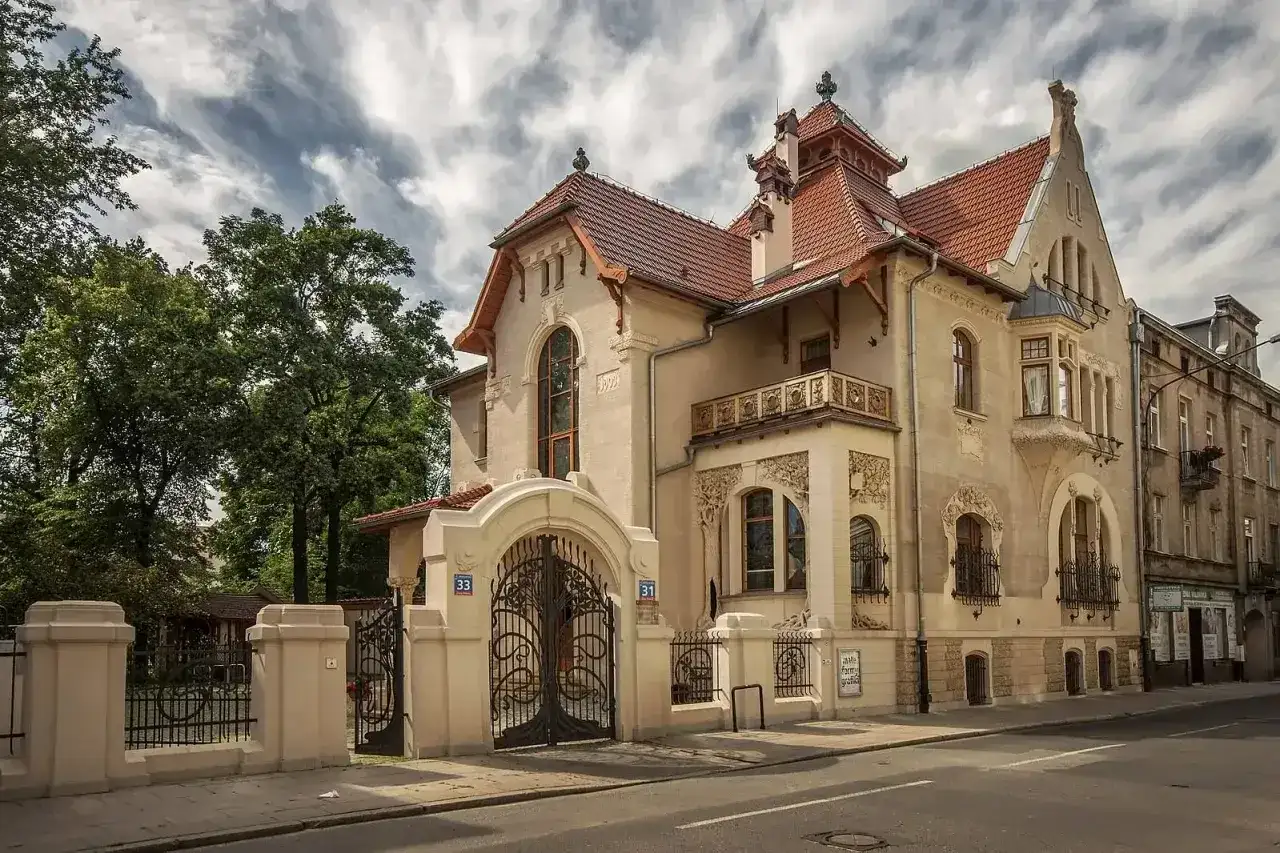 Elegancka willa w stylu secesja Młoda Polska, z bogatymi zdobieniami i kutą bramą.