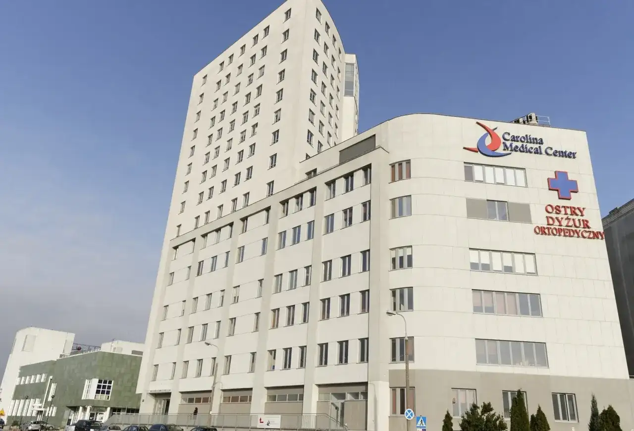 Nowoczesny budynek Carolina Medical Center w Warszawie z napisem "Ostry Dyżur Ortopedyczny".