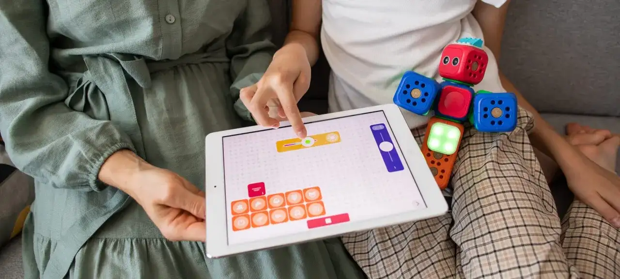 Plan pracy terapeutycznej z dzieckiem autystycznym: interaktywna zabawa z klockami i tabletem, rozwijająca logiczne myślenie i kreatywność.