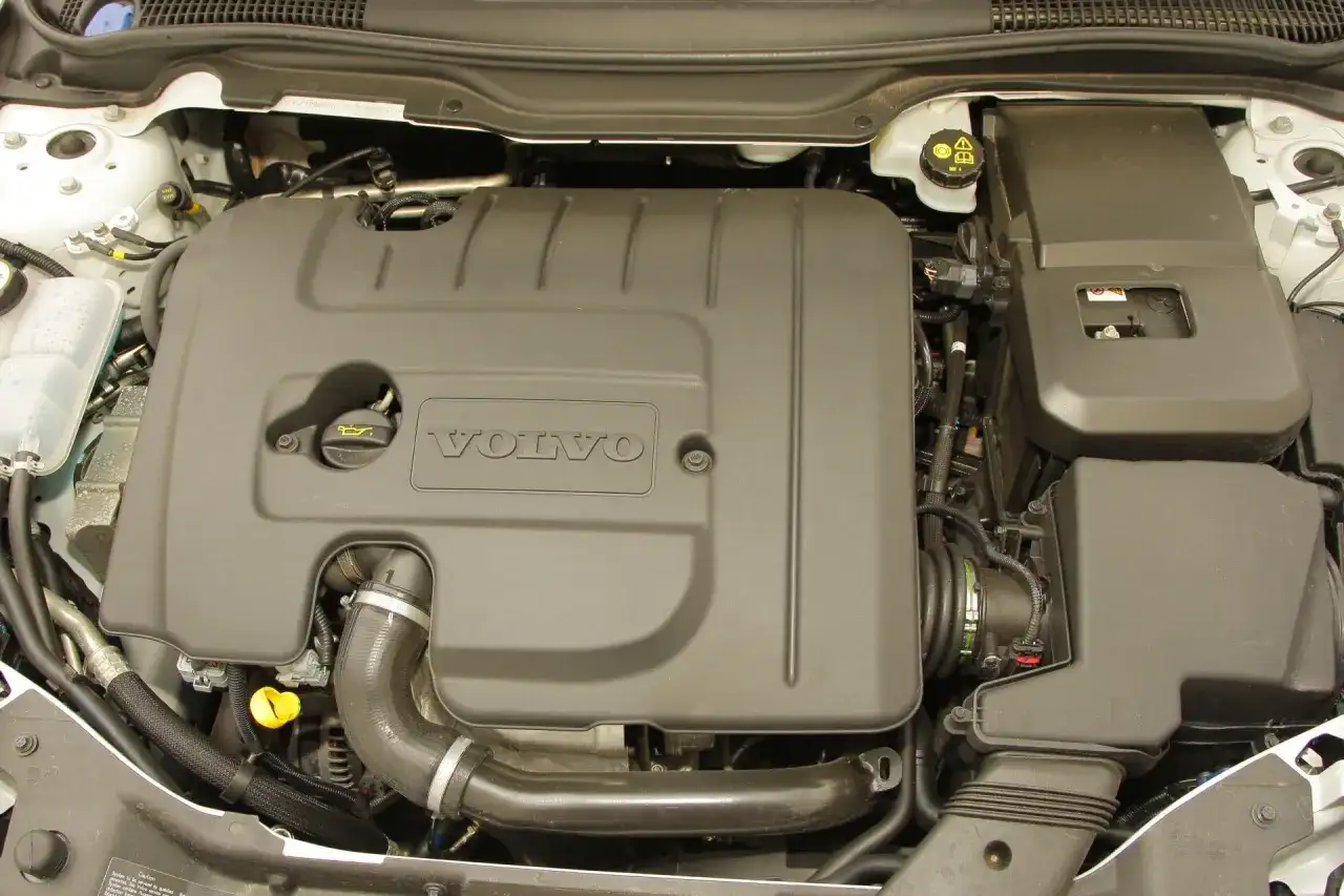 Silnik Volvo V50 1.6 diesel. Widoczna osłona silnika z logo Volvo, przewody i elementy układu dolotowego.