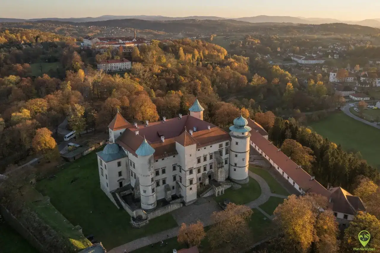 Zamek w jesiennej scenerii, otoczony złotymi liśćmi. Idealne miejsce na jesienny thanksgiving.