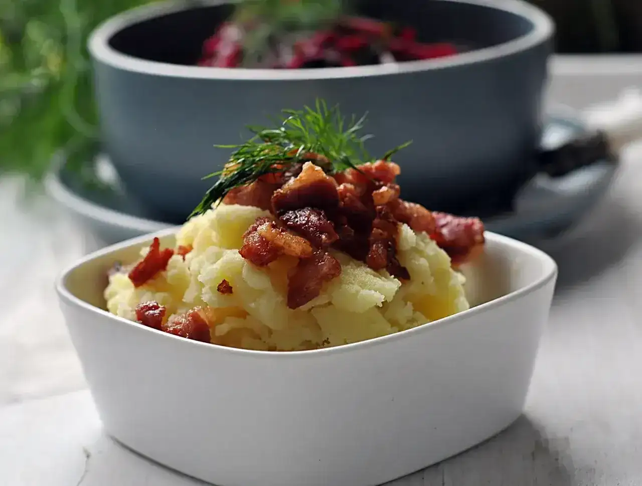Pyszna zupa z botwiny z ziemniakami, podana z chrupiącym boczkiem i koperkiem.