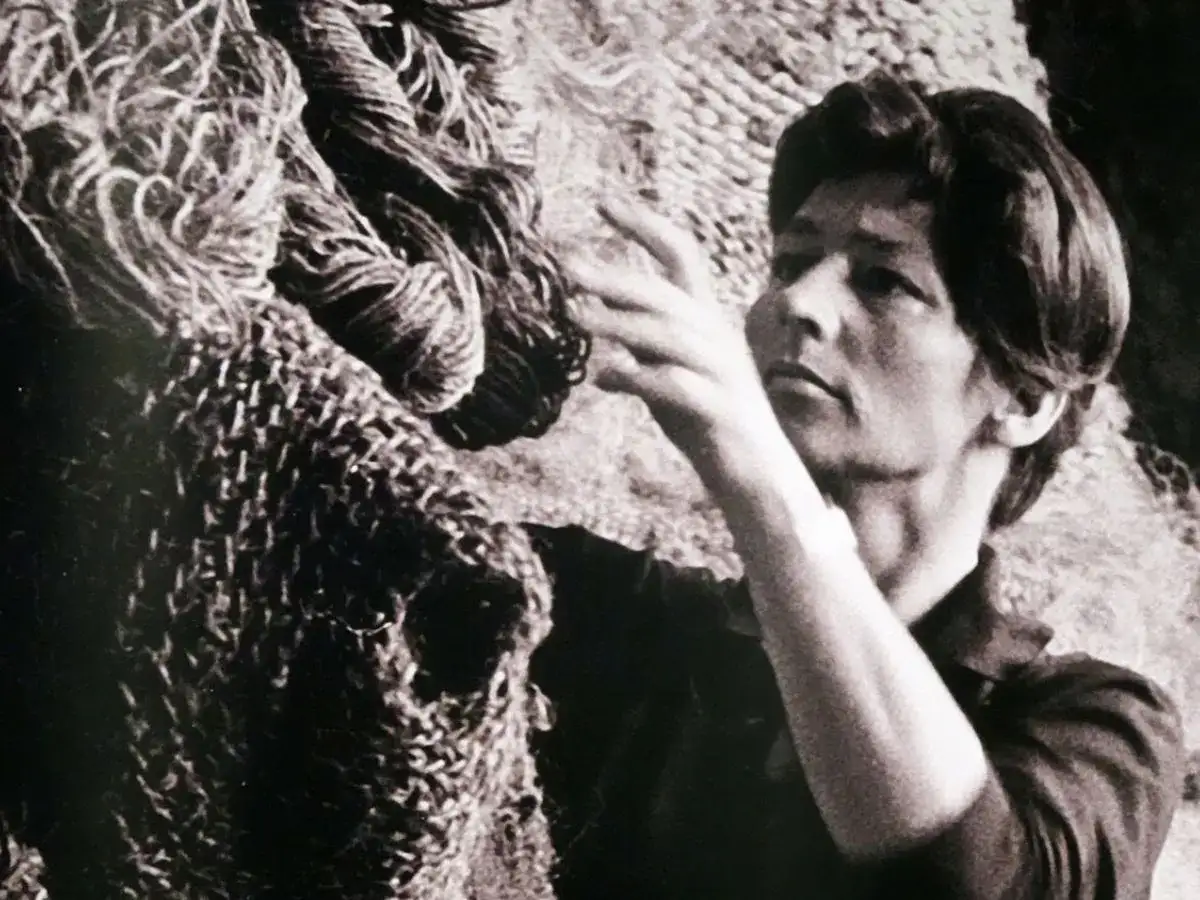 Magdalena Abakanowicz z dłońmi wśród swoich monumentalnych, plecionych dzieł, abakanów.