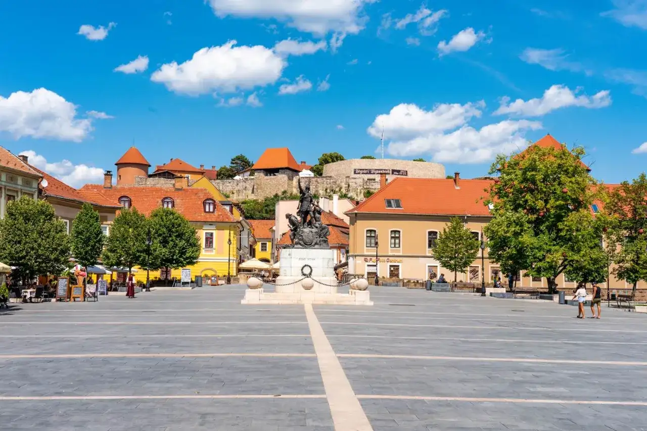 Rynek w Egerze z pomnikiem i zamkiem w tle. Wspaniałe atrakcje turystyczne i piękne widoki.