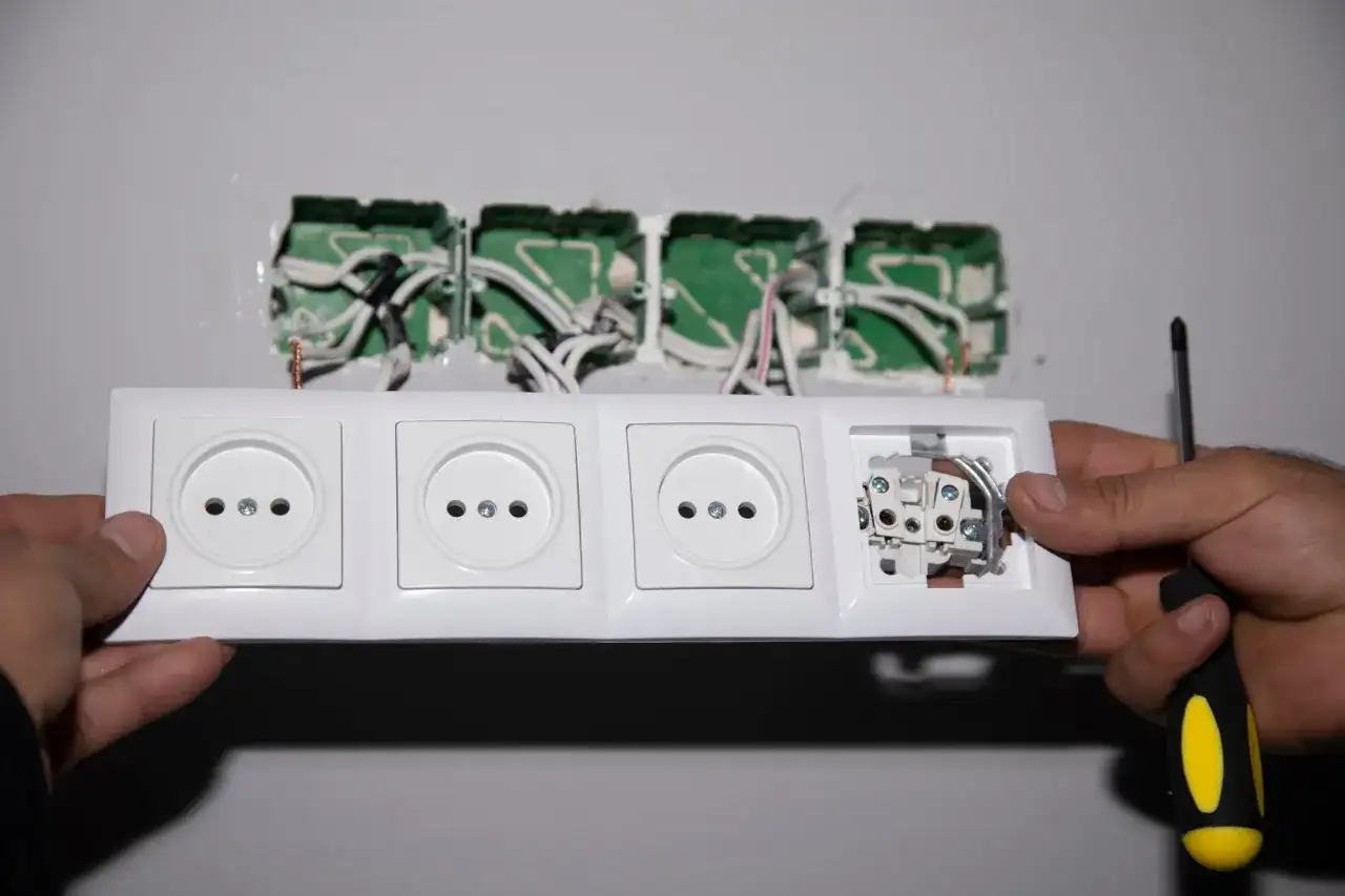 Montaż gniazdek elektrycznych. Widać przewody wychodzące z puszki instalacyjnej i przygotowywane do podłączenia. To pierwszy krok, by dowiedzieć się, jak podłączyć licznik jednofazowy orno.
