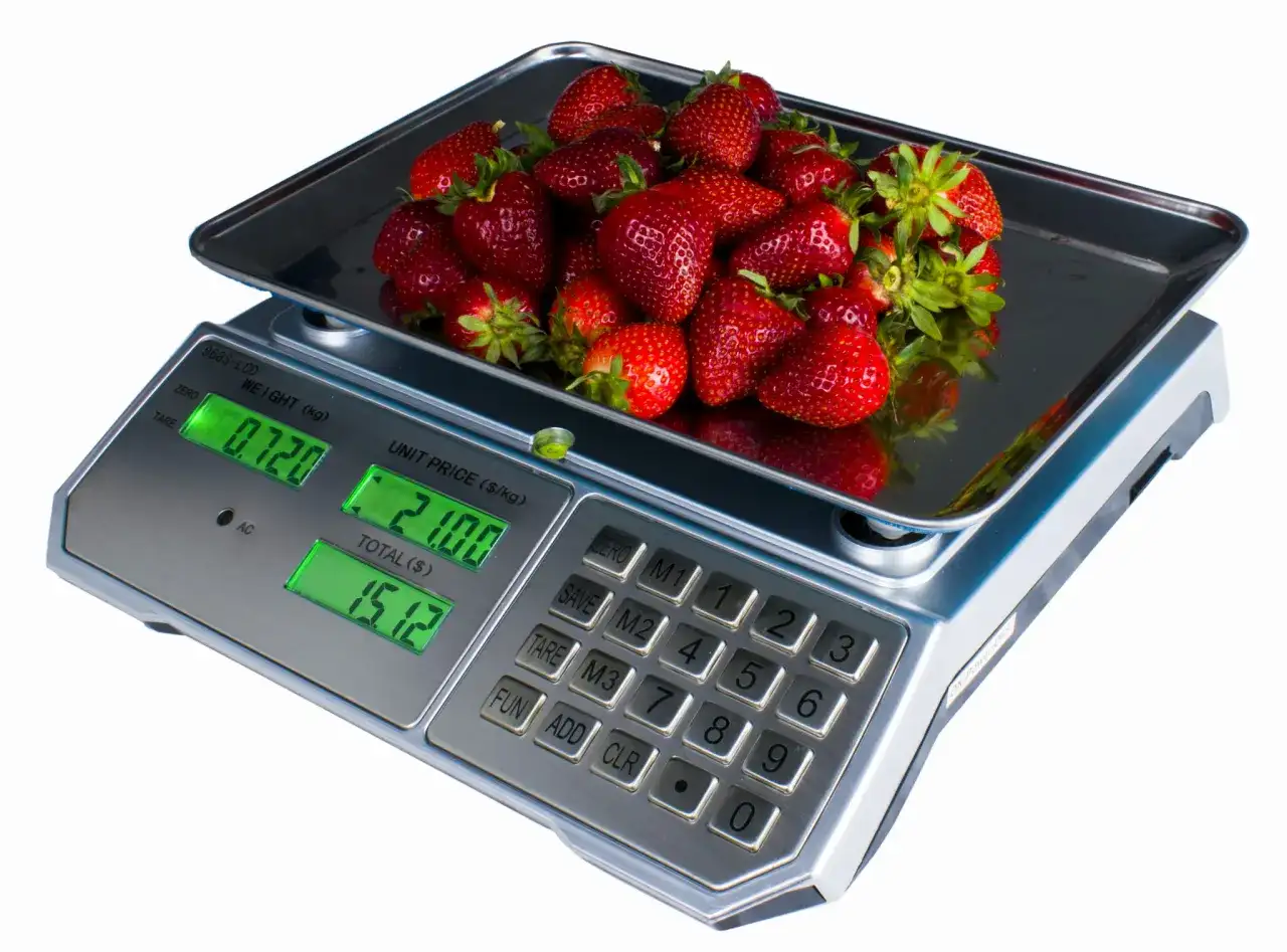 Kobiałka pełna soczystych truskawek waży się na wadze cyfrowej, pokazując 0.720 kg.