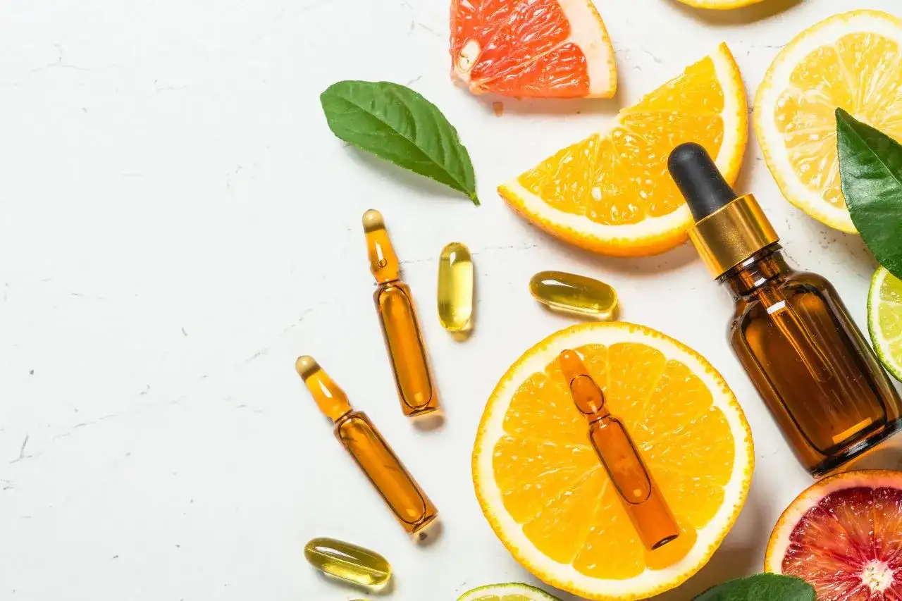 Kapsułki z witaminą E (tocopheryl acetate) i cytrusy, symbol odżywienia i naturalnej pielęgnacji.