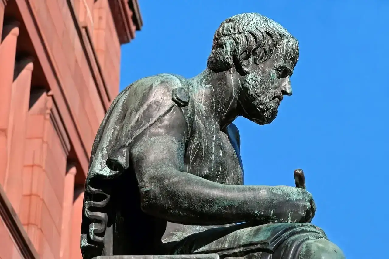 Posąg filozofa, który zgłębia tajniki bytu i ontologii, siedząc z piórem w dłoni.