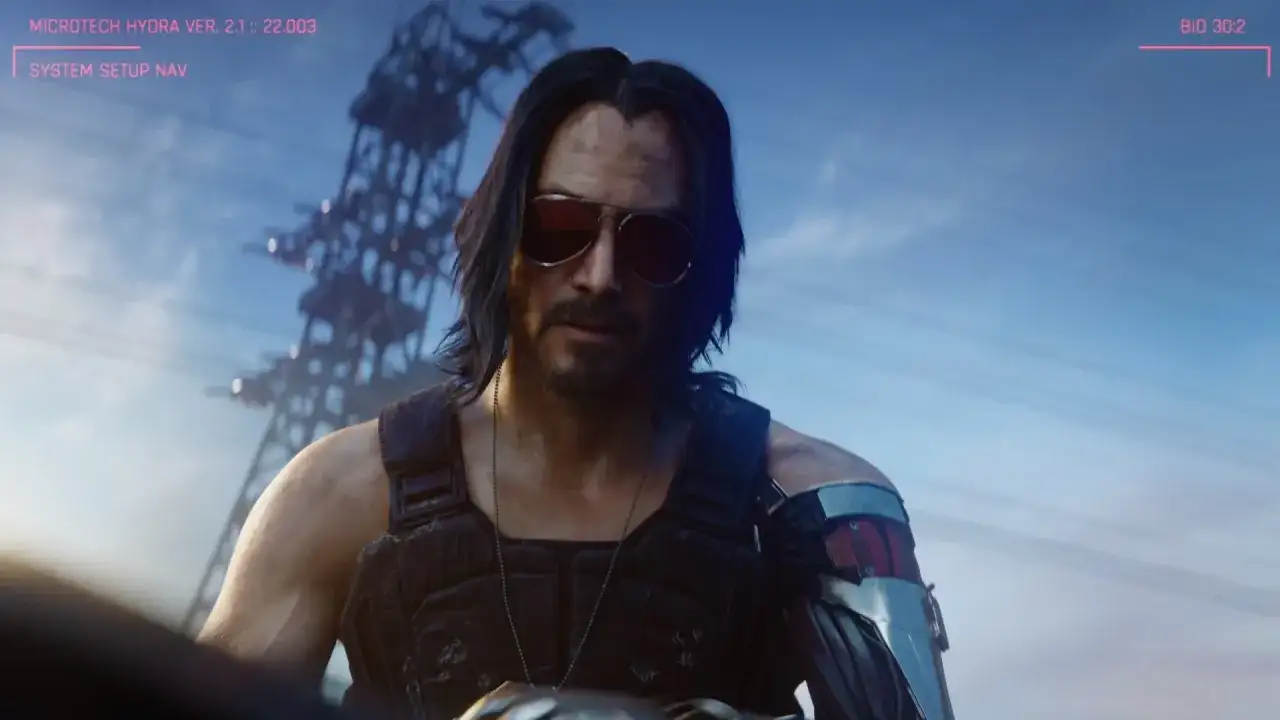 Johnny Silverhand, aktor w okularach przeciwsłonecznych i z cybernetycznym ramieniem, patrzy w obiektyw.