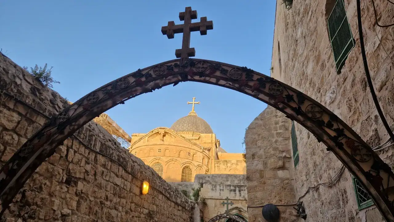 Kamienna brama z krzyżem i kopułą kościoła, jak w psalm 122, zaprasza do Jerozolimy.