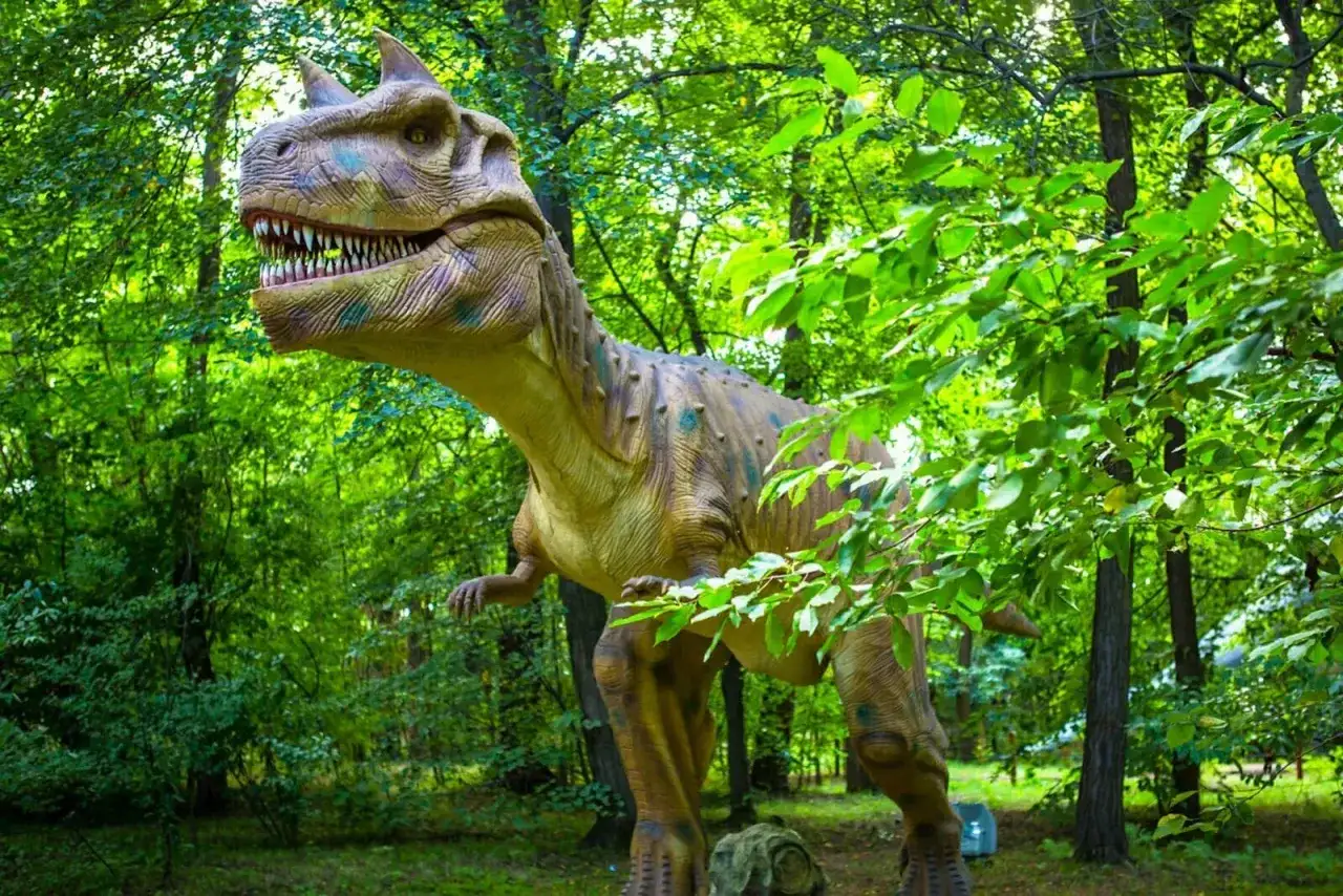 Witaj w parku ruchomych dinozaurów! Gigantyczny, realistyczny model tyranozaura czeka na Ciebie wśród bujnej zieleni.