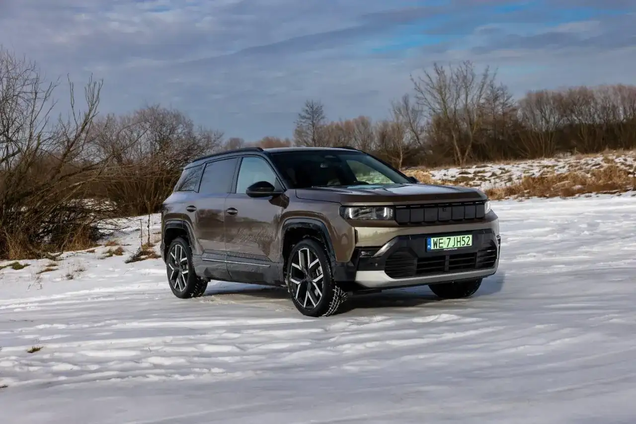Nowy Jeep Compass w brązowym kolorze na tle zimowego krajobrazu. Gotowy na przygodę w śniegu.