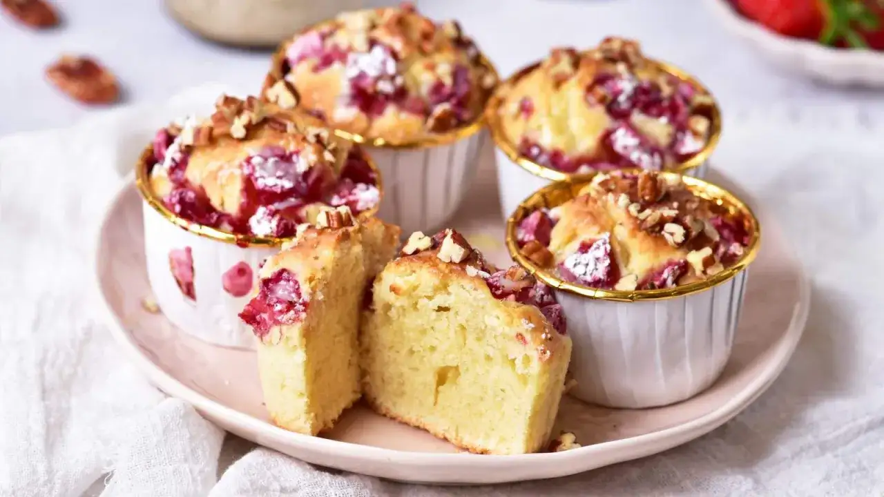 Puszyste muffinki z truskawkami, posypane orzechami, kuszą swoim wyglądem i zapachem. Idealne na deser.