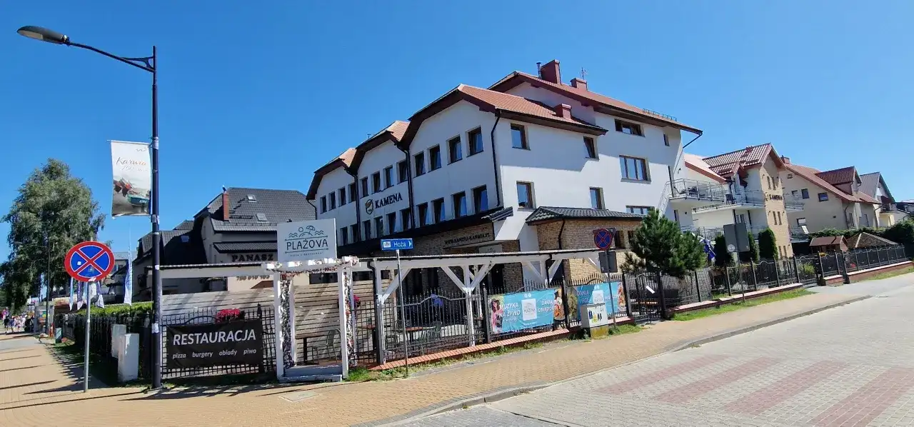 Ośrodek Kamena Karwia to biały budynek z czerwonym dachem, obok restauracja Plażova.