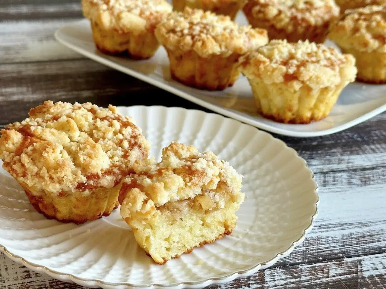 Pyszne muffinki z jabłkami, z kruszonką na wierzchu, prezentowane na białym talerzyku.