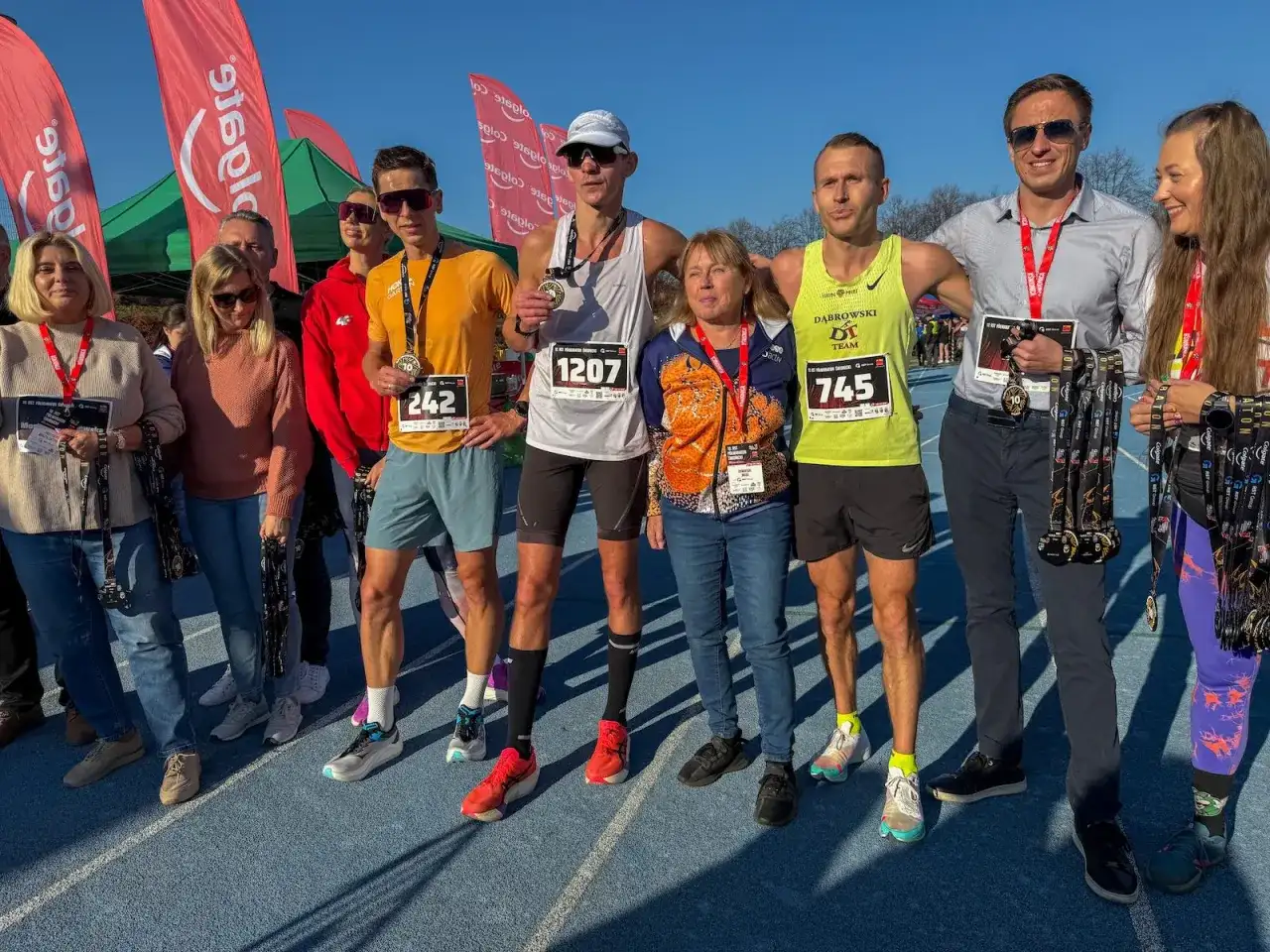 Uczestnicy biegu z medalami, zastanawiają się co zjesc przed biegiem, by osiągnąć sukces.