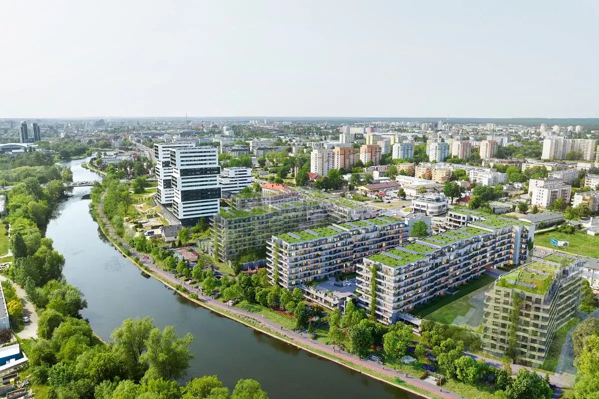 Nowoczesne osiedle apartamentowe z zielonymi dachami nad rzeką w Bydgoszczy.