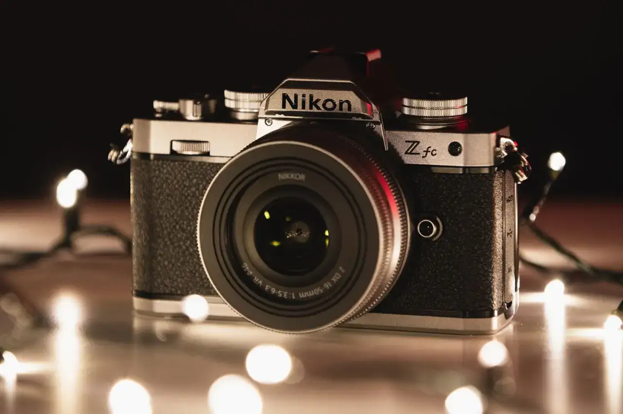 Nikon Z fc, jeden z rodzajów aparatów, otoczony świątecznymi lampkami.