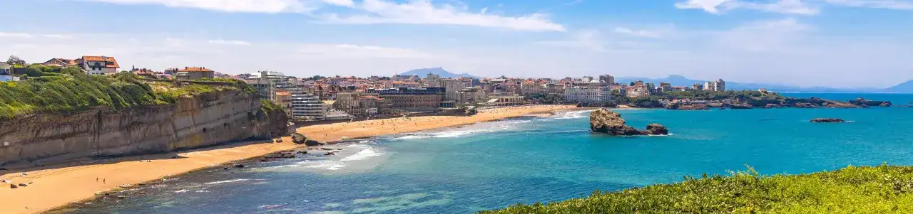 Traumhafter Frankreich Urlaub am Meer: Küstenstadt mit Sandstrand, Felsen und türkisfarbenem Wasser.