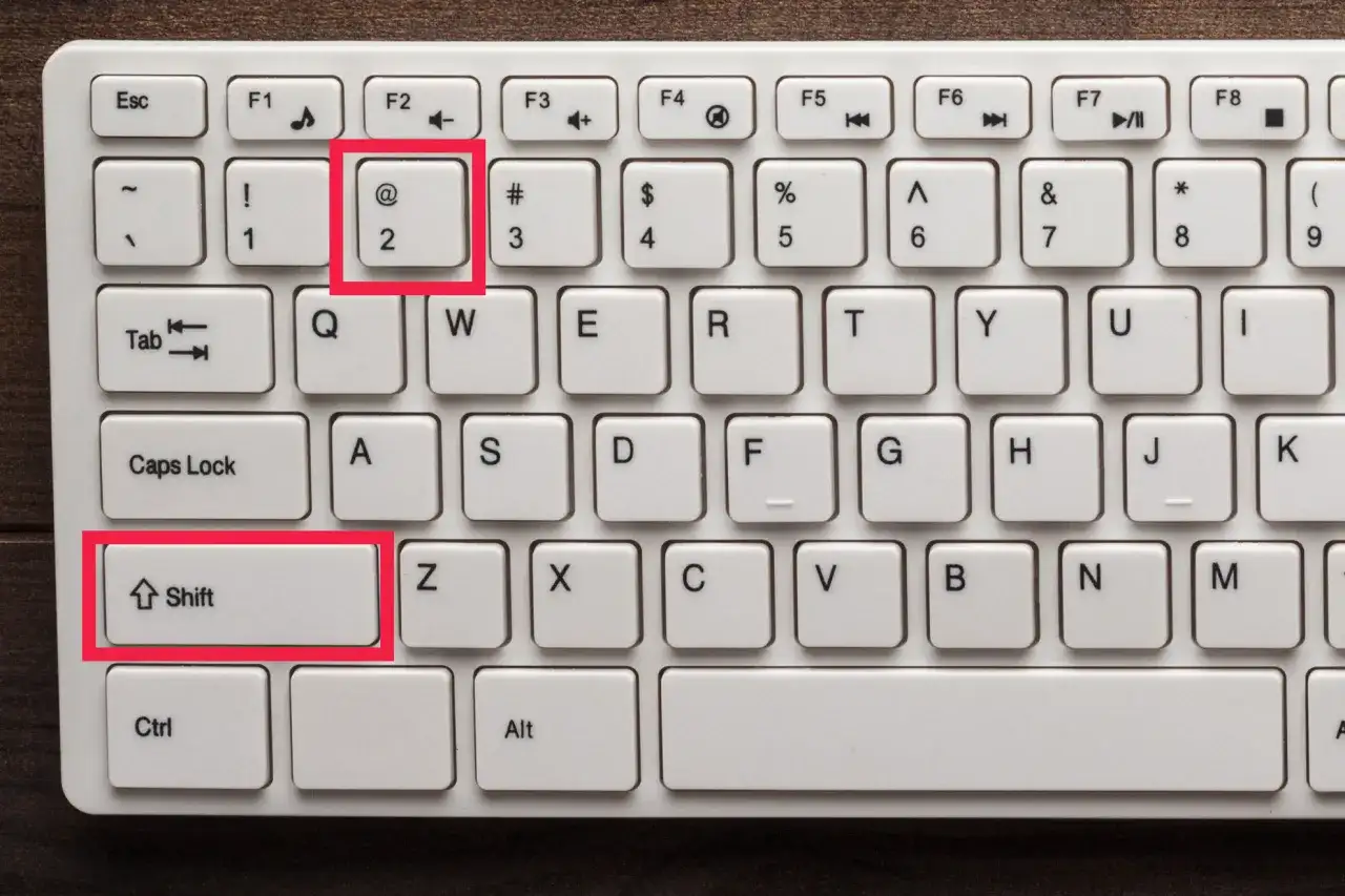 Klawiatura z zaznaczonymi klawiszami Shift i 2 (@). Chcesz wiedzieć, jak zrobic małpe na laptopie?