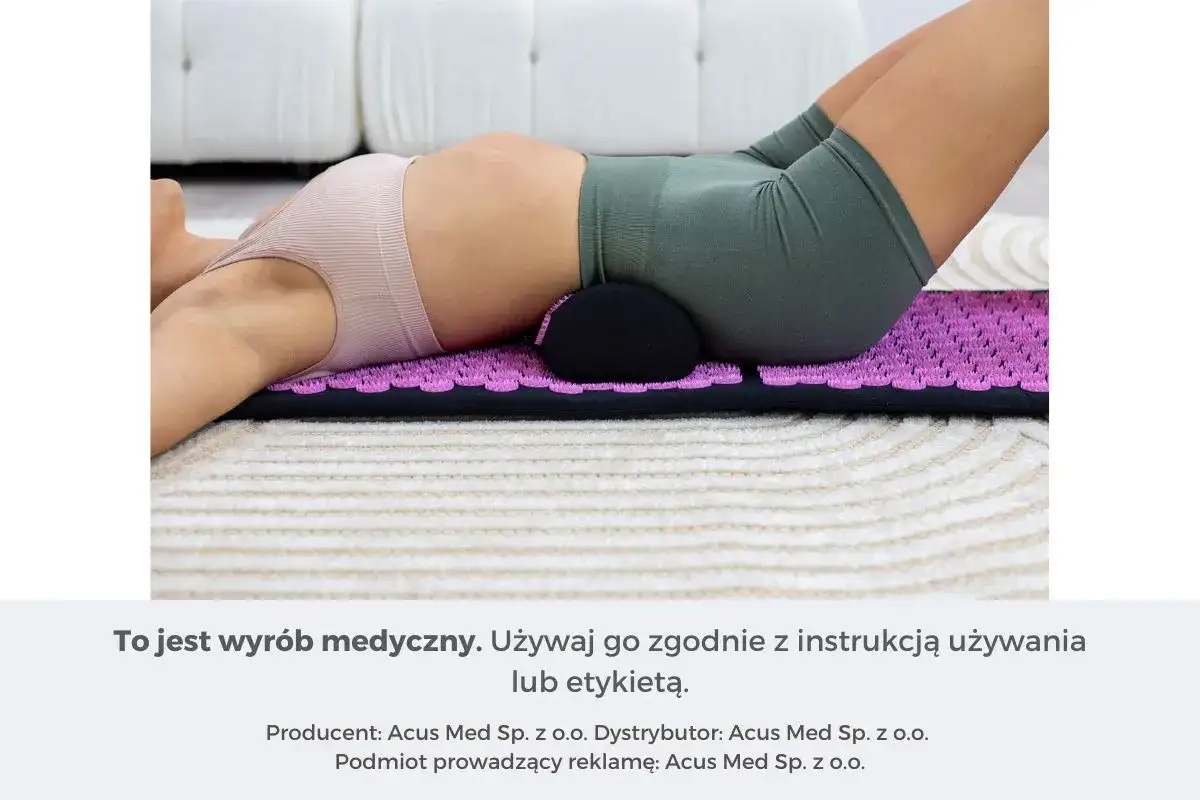 Osoba leży na macie akupresurowej z wałkiem pod odcinkiem lędźwiowym, łagodząc ból kręgosłupa lędźwiowego przy leżeniu.