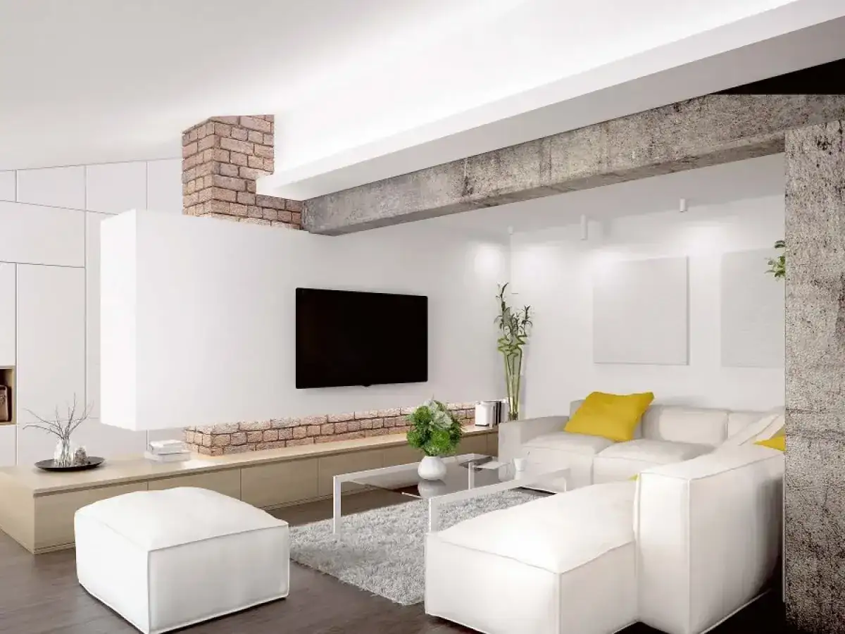 Nowoczesny salon z białym narożnikiem, telewizorem i ceglanym elementem architektonicznym, który pełni funkcję podciągu zamiast ściany nośnej.