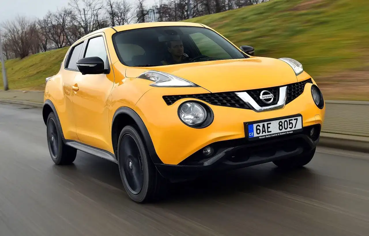 Żółty Nissan Juke pędzi po drodze, kierowca skupiony na trasie.
