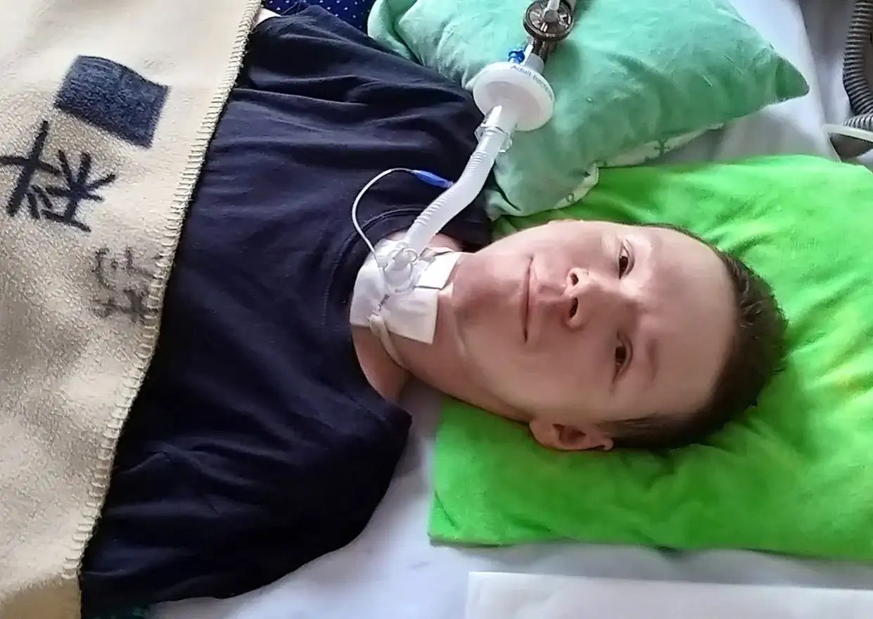 Chłopiec z chorobą DMD leży w łóżku, podłączony do respiratora.