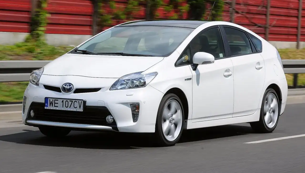 Biały Toyota Prius 3 na drodze, z widocznym numerem rejestracyjnym WE 107CV.