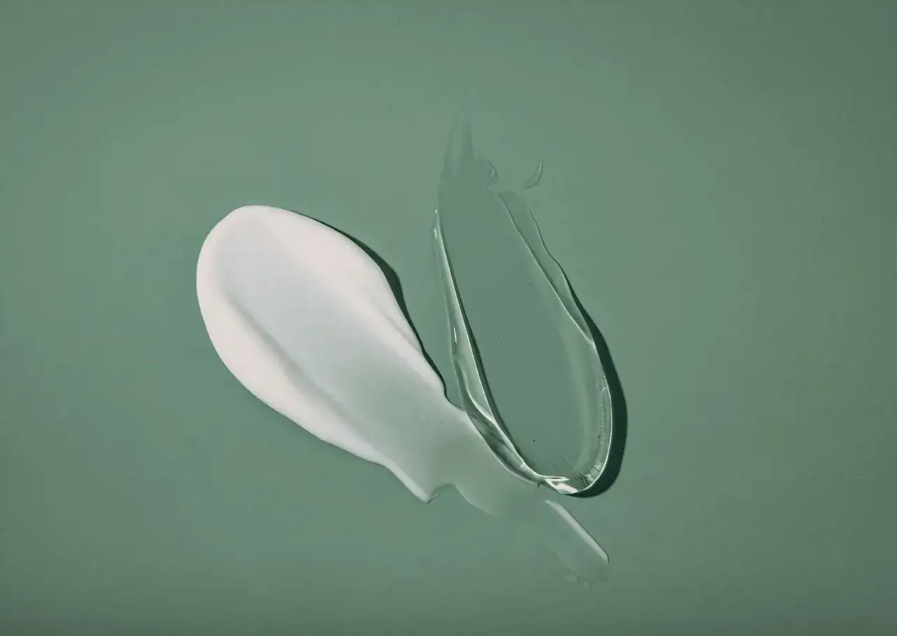 Biały krem i przezroczysty żel na zielonym tle. Połączenie niacynamidu i retinolu dla idealnej cery.