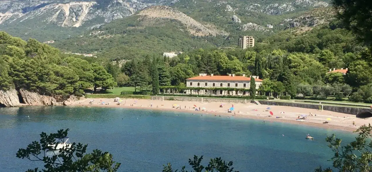 Piękne czarnogóra plaże z turkusową wodą, piaszczystym brzegiem i luksusową willą w tle.
