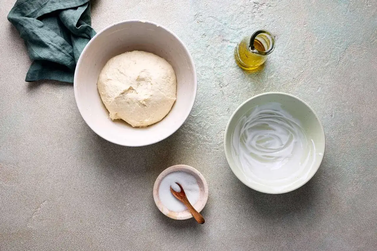 Zutaten für Pfannenbrot mit Joghurt: Teig, Joghurt, Öl und Salz bereitgestellt.
