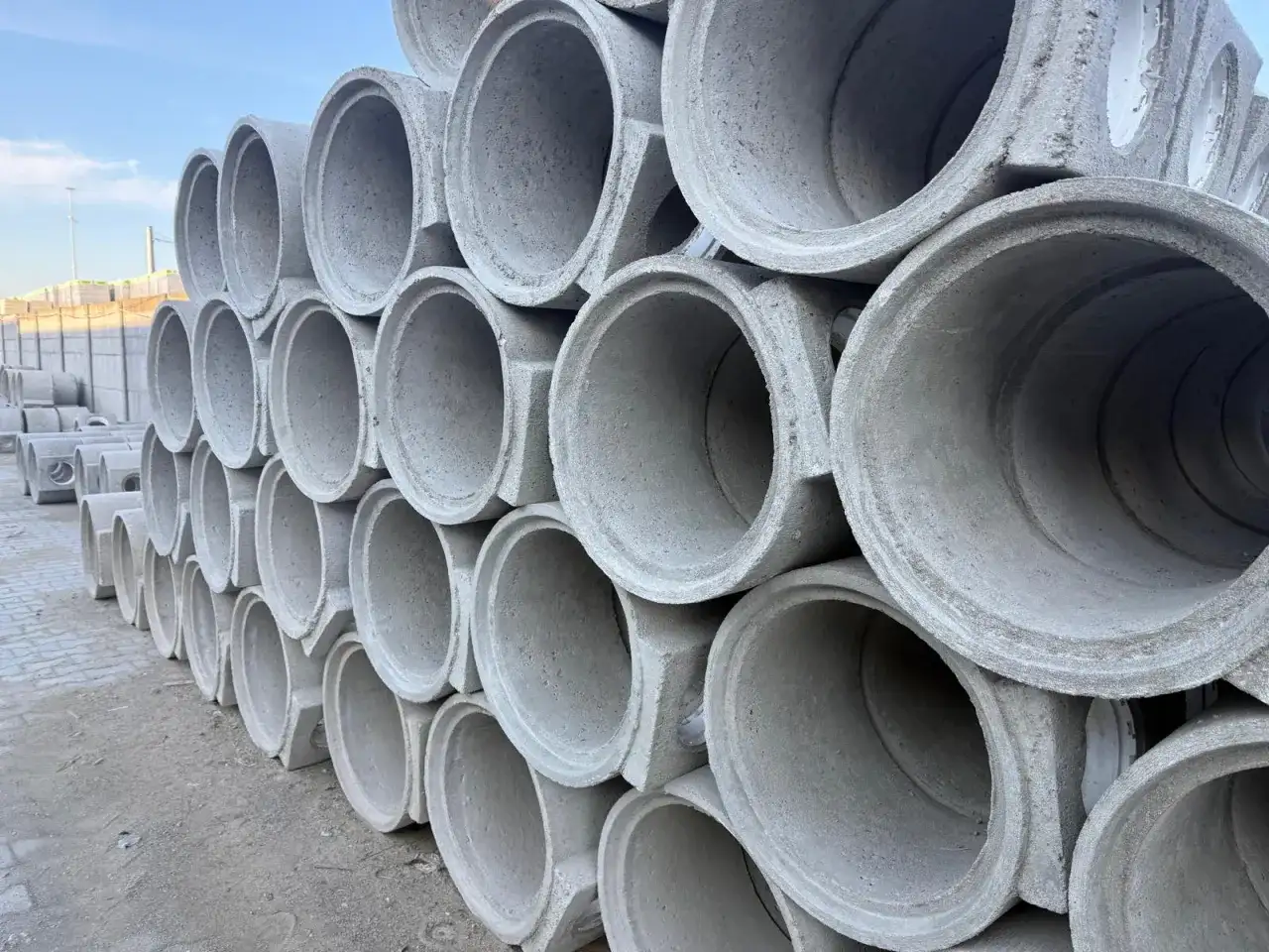 Stos betonowych rur kanalizacyjnych. Każda rura ma pojemność kręgu betonowego 100, gotowa do budowy infrastruktury.