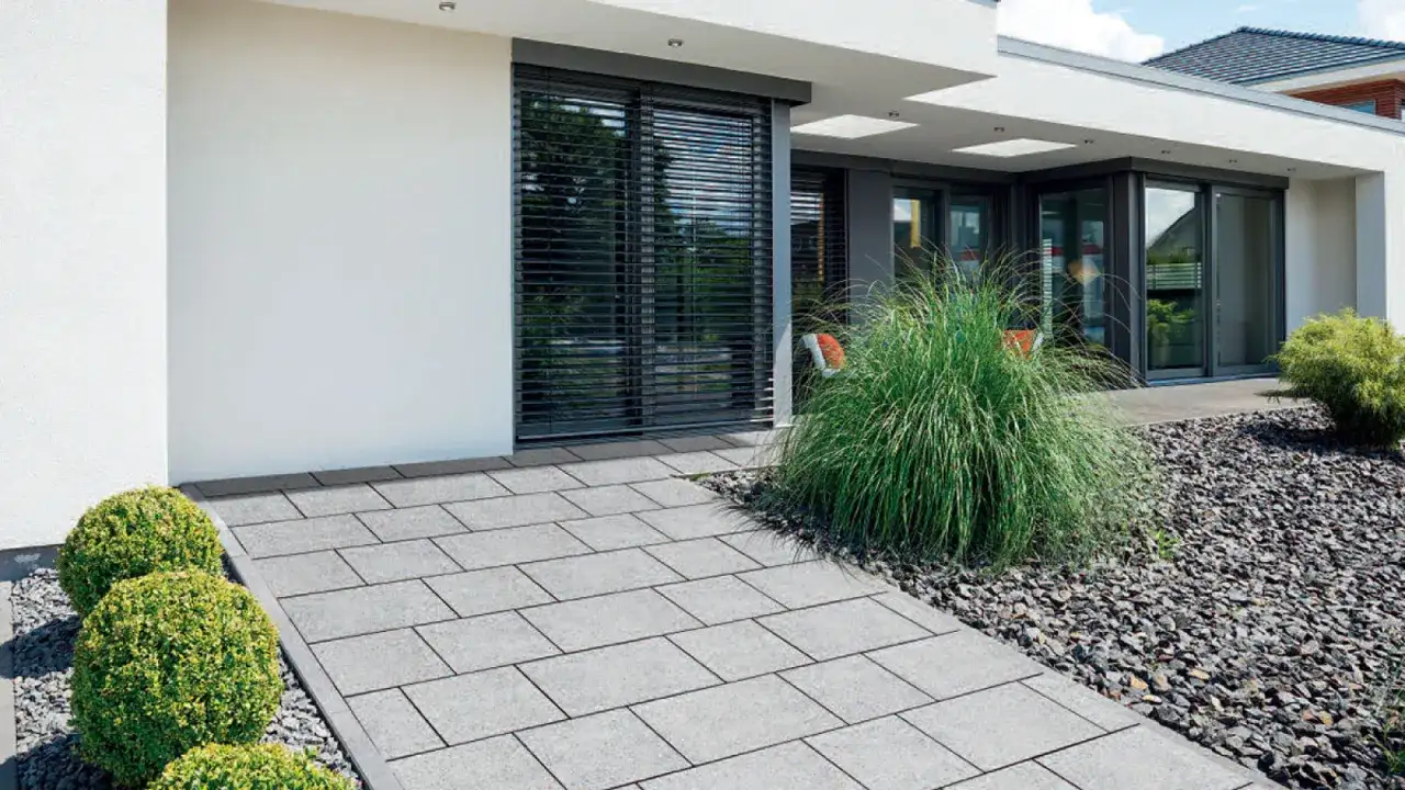 Nowoczesna ścieżka z szarej kostki granitowej, której wymiary idealnie komponują się z minimalistyczną architekturą domu.