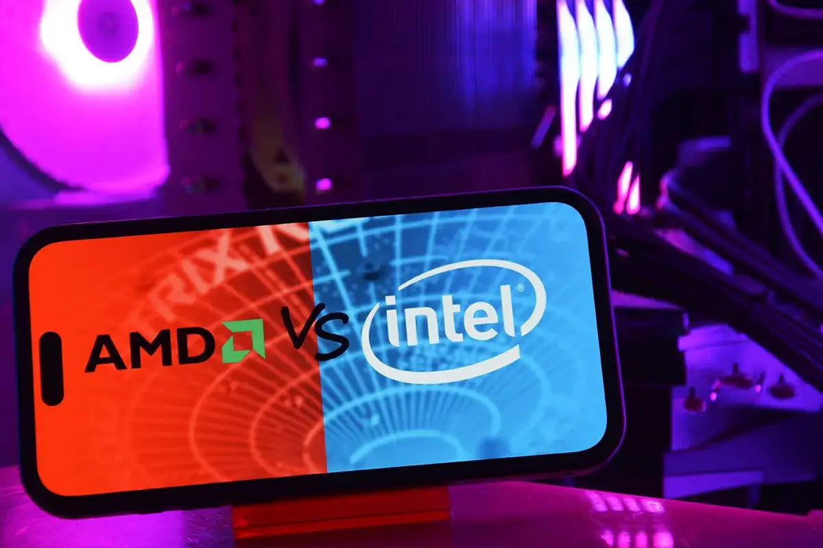 Porównanie procesorów: AMD vs Intel na ekranie smartfona, w tle świecące elementy komputera.