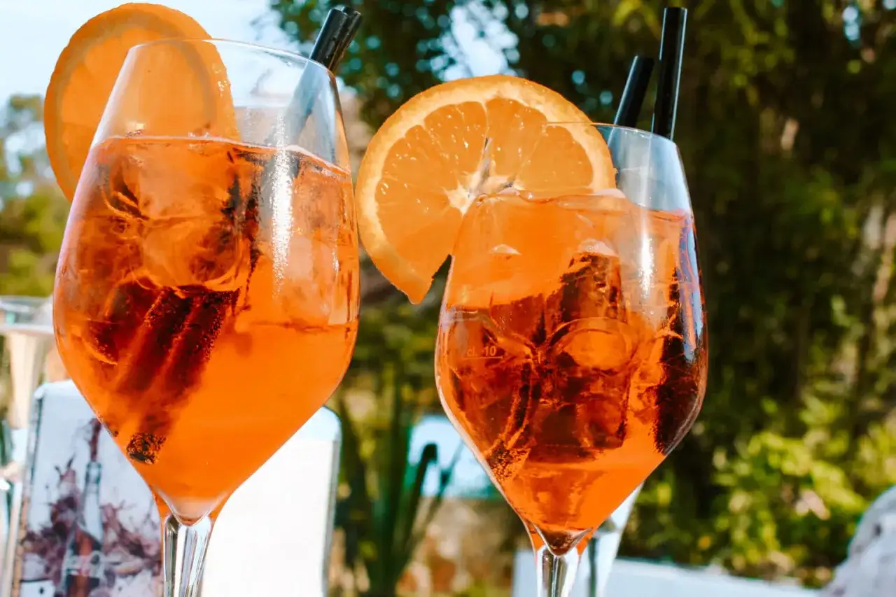 Dwa orzeźwiające drinki z pomarańczą i lodem, idealne na włoski aperitif.
