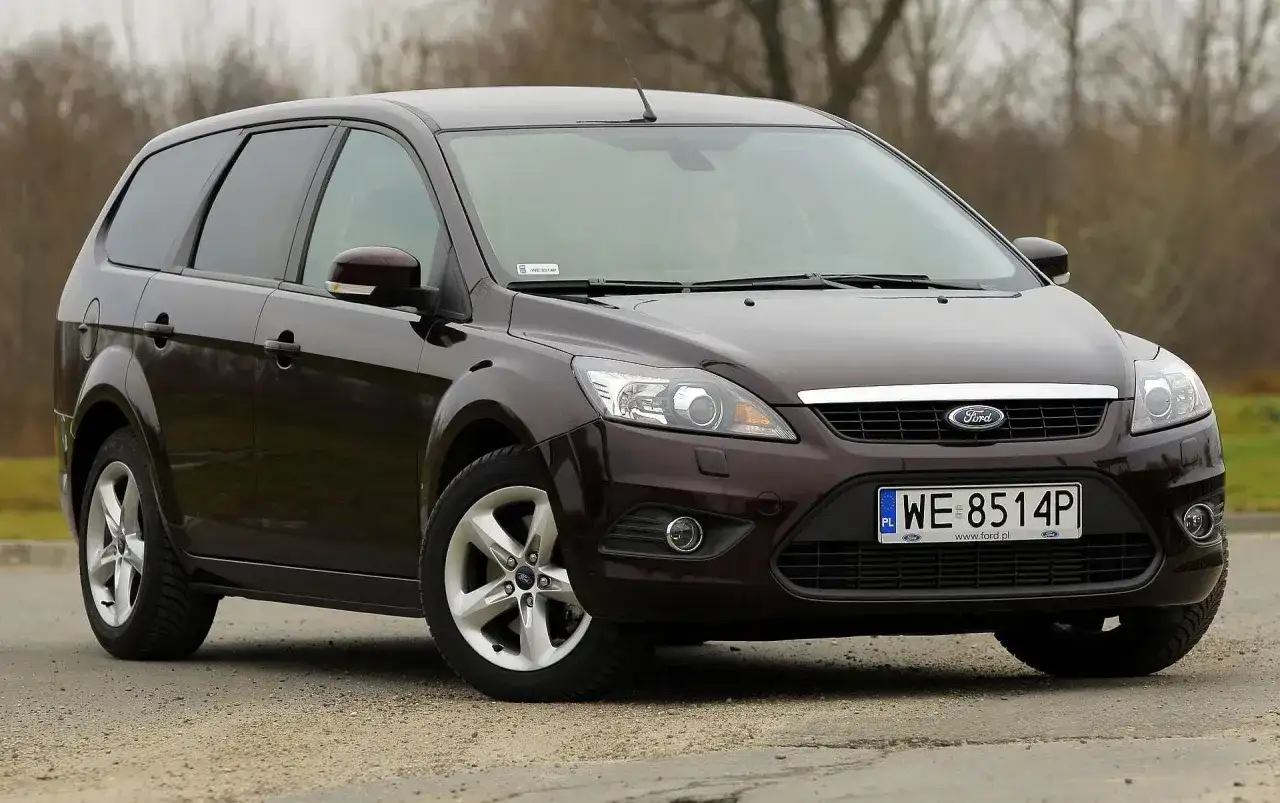 Ciemnobrązowy Ford Focus MK2 1.6 TDCI kombi stoi na szutrowej drodze.