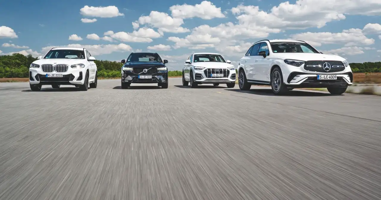 Białe i czarne SUV-y, w tym modele Mercedes, jadące po drodze.