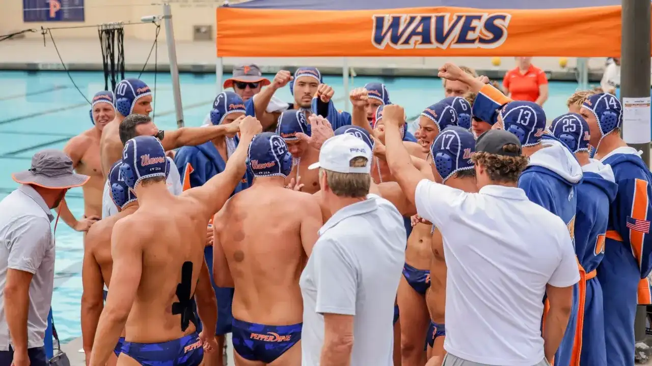 Waterpolo development: A team huddles, fists raised, showing unity and focus before a game.