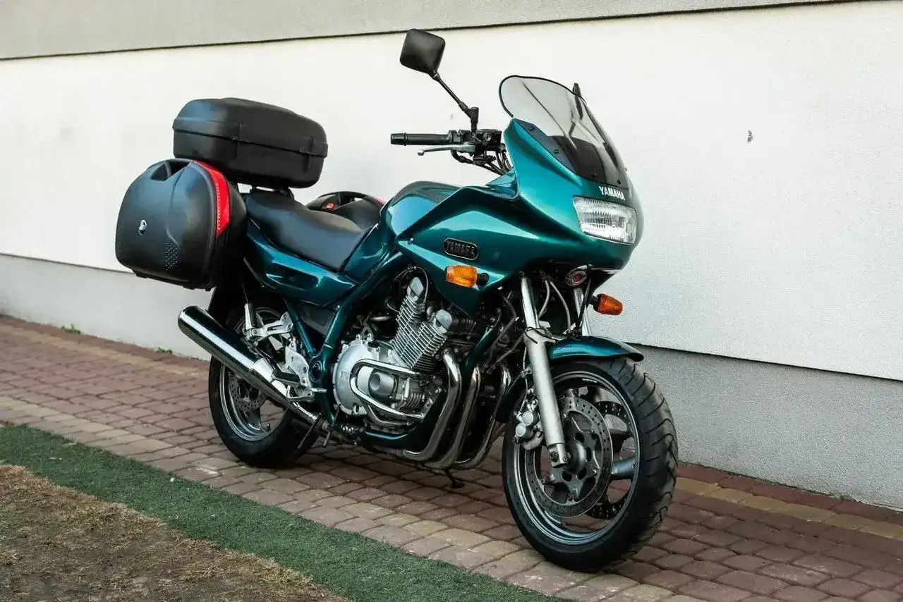 Zielony motocykl Yamaha XJ 900 z kuframi, gotowy na daleką podróż.