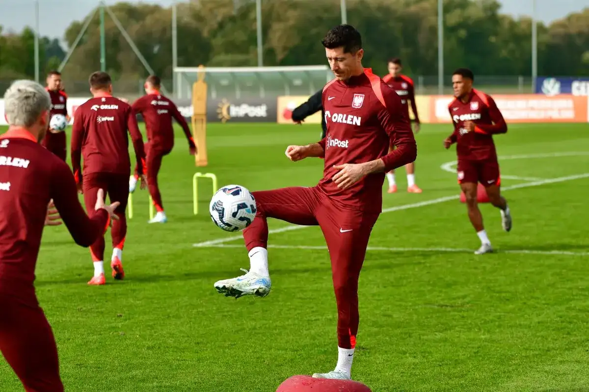 Piłkarz Robert Lewandowski ćwiczy drybling, pokazując, jaki jest najpopularniejszy sport na świecie.