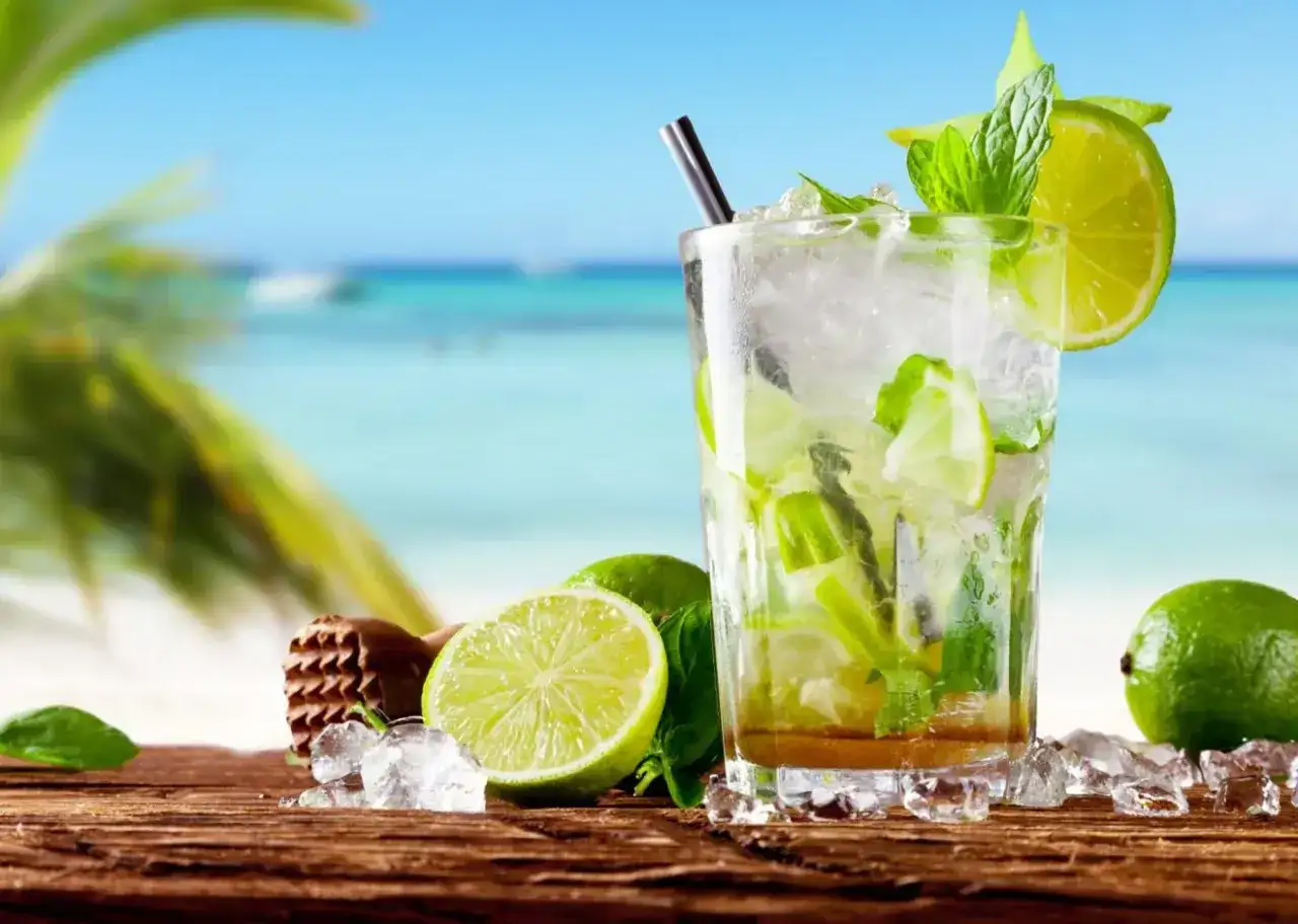 Orzeźwiający mohito alkohol z limonką i miętą na tle plaży. Idealny na wakacje!