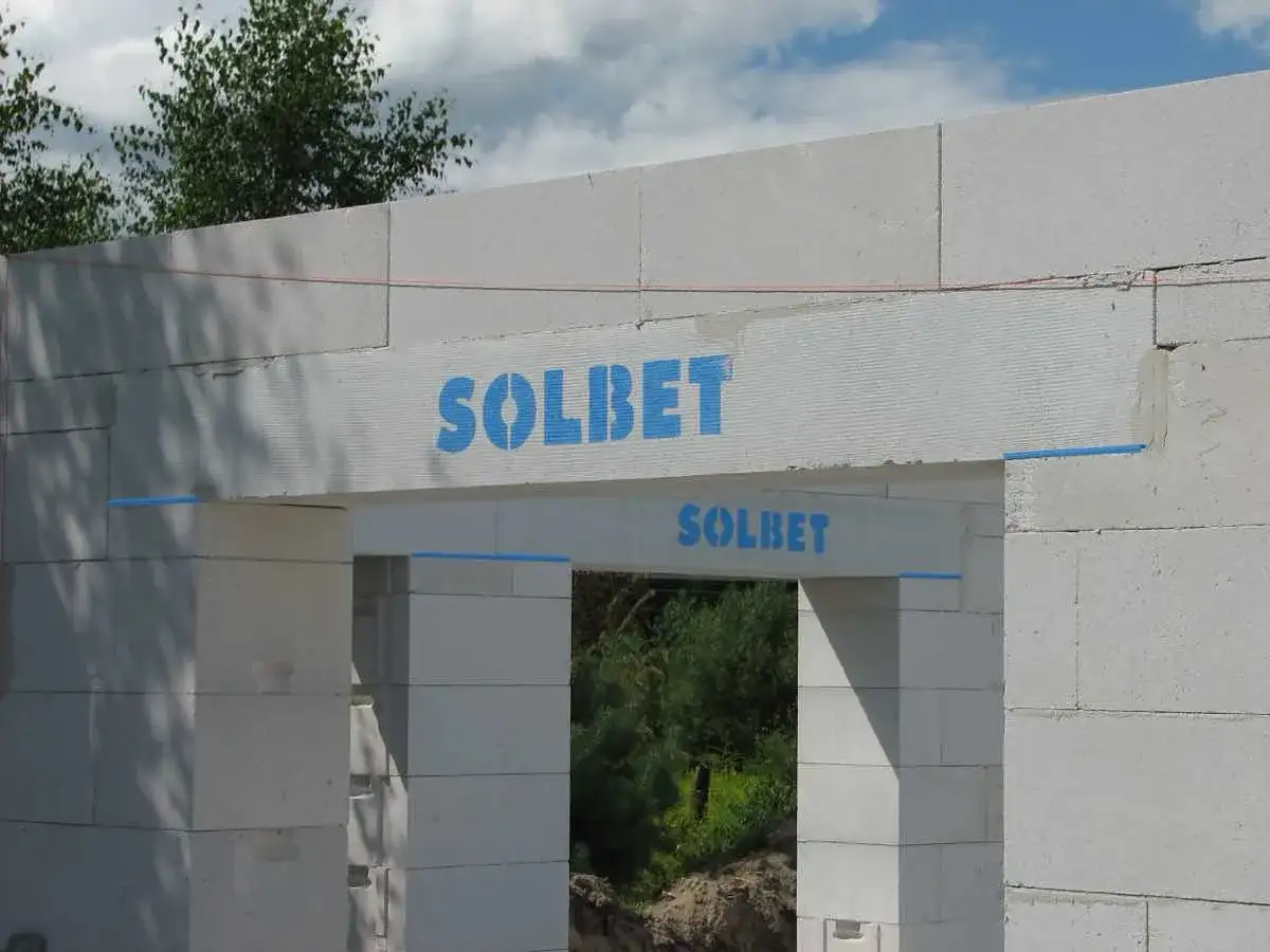 Kształtki wieńcowe Solbet na budowie domu. Elementy konstrukcyjne z widocznym logo producenta.